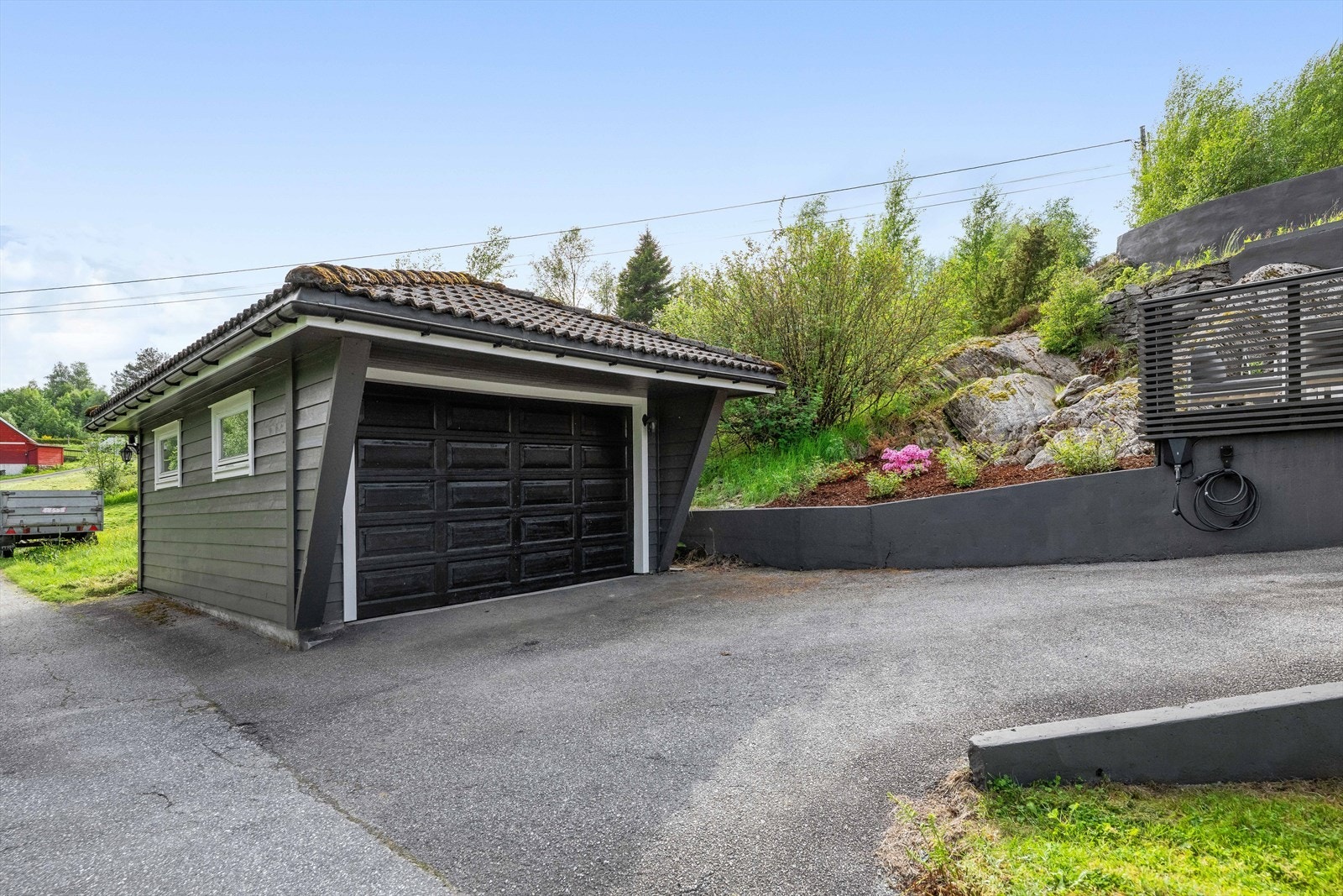 Det medfølger også garasje med god plass for bil og oppbevaring. Garasjen har innlagt strøm, og utenfor finner man lader til el-bil. Galleribilde