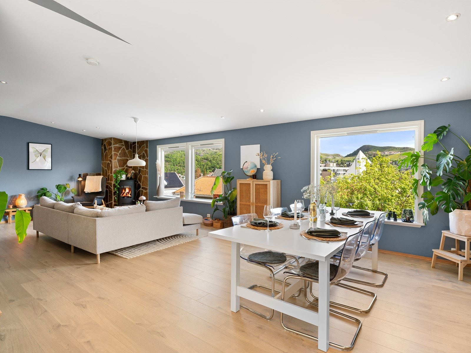 Den romslige stuen har plass til både en stor sofagruppe og en egen spiseavdeling. Galleribilde