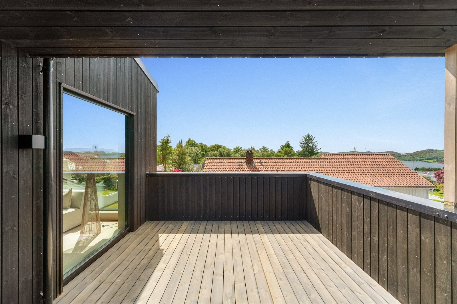 Romslig og overbygd terrasse med gode møbleringsmuligheter, skjermet beliggenhet og flott utsyn mot nærområdet. Galleribilde