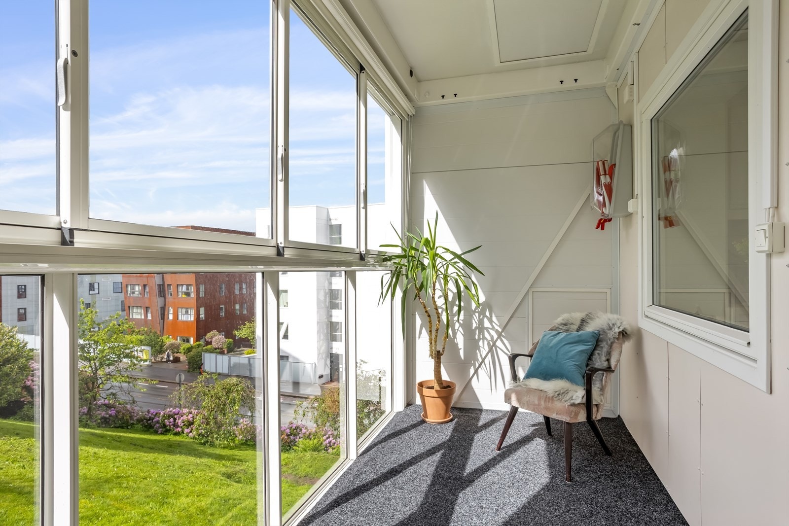 Den innglassede balkongen gir et lunt og anvendelig uterom med utsikt over grøntområdene. Galleribilde