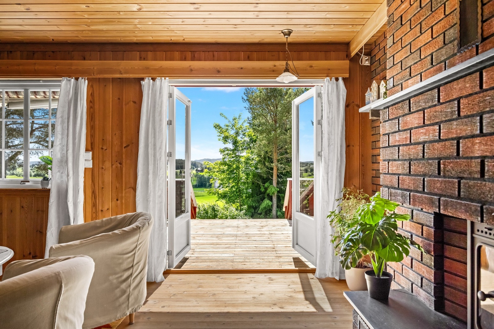 Store vindusflater og terrassedør slipper inn godt med dagslys og gir utsyn mot landlige omgivelser. Galleribilde