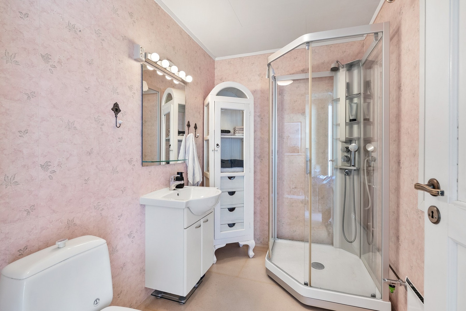 Badet i første etasje er fra byggeåret og har dusjkabinett, servantinnredning og gulvmontert toalett. Galleribilde