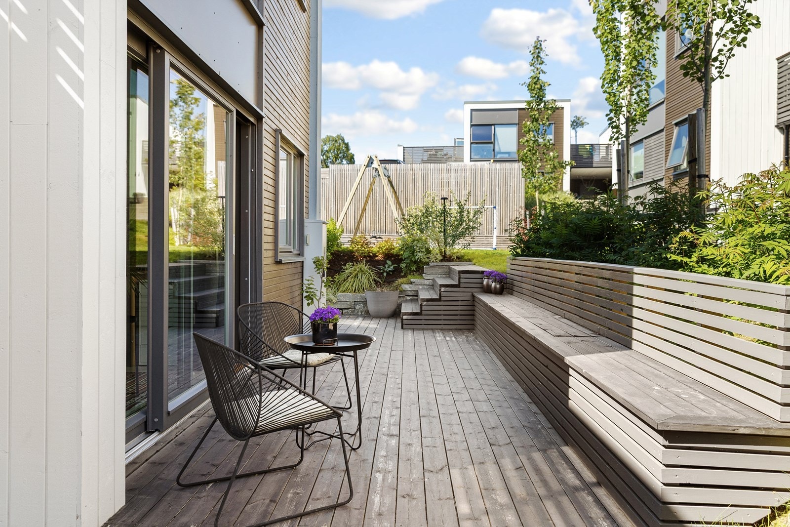 En støttemur i Altaskifer, satt opp i 2023, rammer inn uteplassen på en elegant måte. Galleribilde
