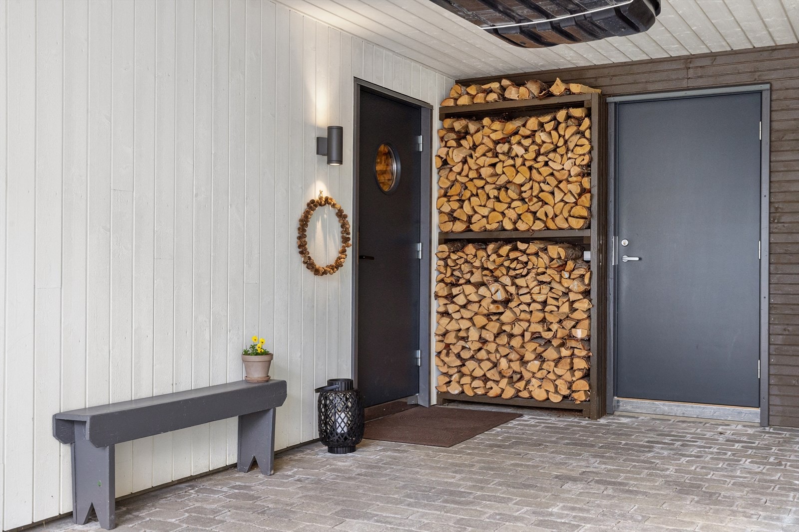 Overbygget inngangsparti som beskytter mot vind og vær. Selger opplyser at sportsboden i enden av carporten er praktisk for lagring av turutstyr, ski og sykler, og at det er plass til sykler og sykkelvogner både bak bil og på siden i carporten. Galleribilde