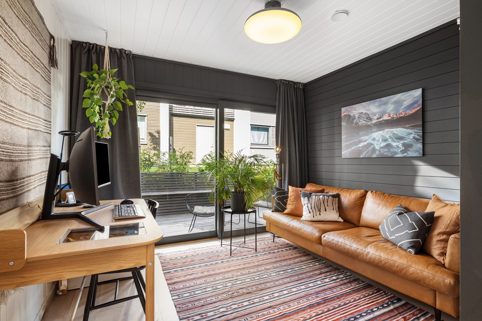 Første etasje har en ekstra stue med direkte utgang til terrasse og hage. Rommet har god plass til sofagruppe og fungerer godt som TV-stue eller et ekstra soverom. Galleribilde
