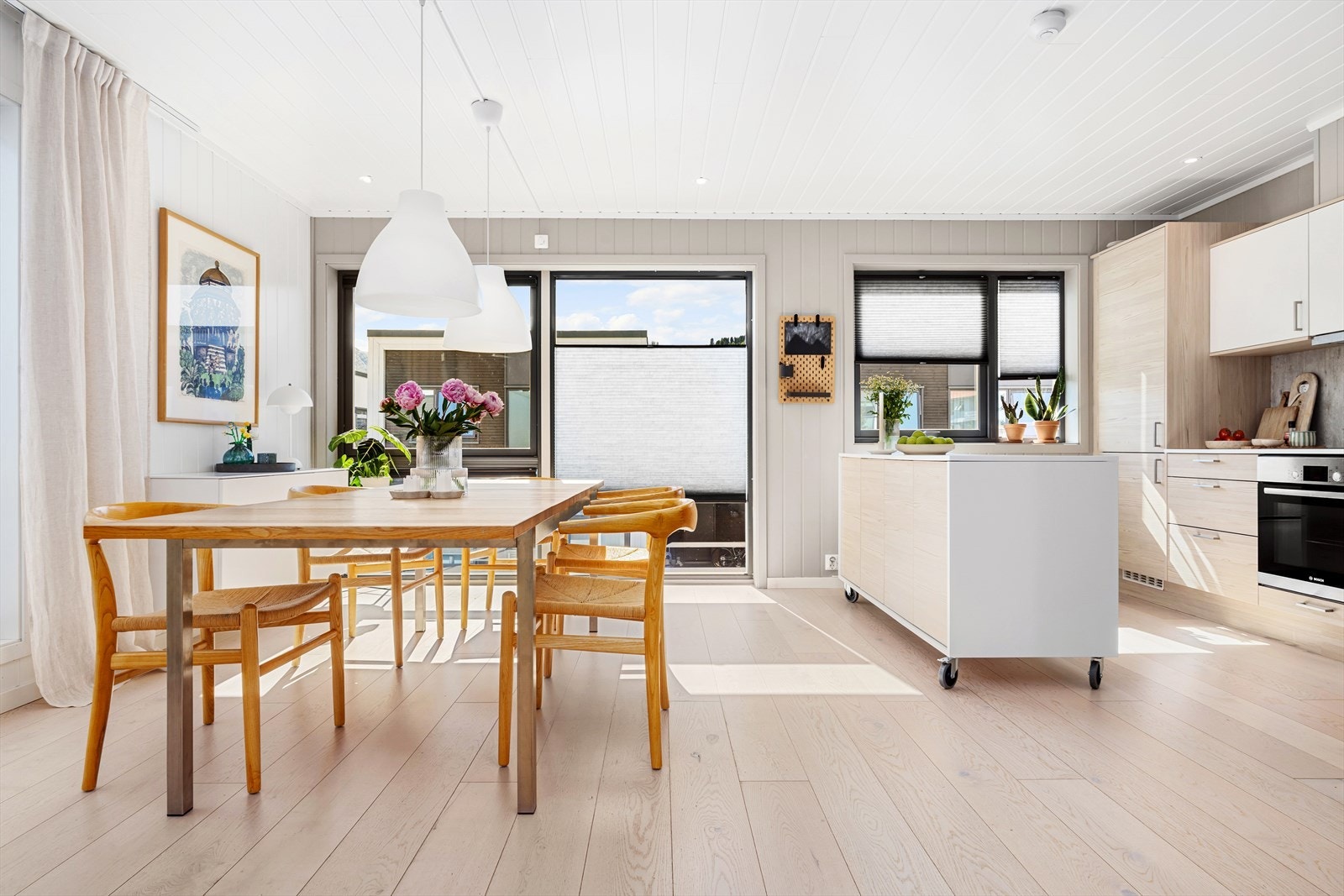 Her legges det til rette for både hverdagsliv og hyggelige sammenkomster, med god plass til både måltider og samvær i en åpen og innbydende løsning. Galleribilde