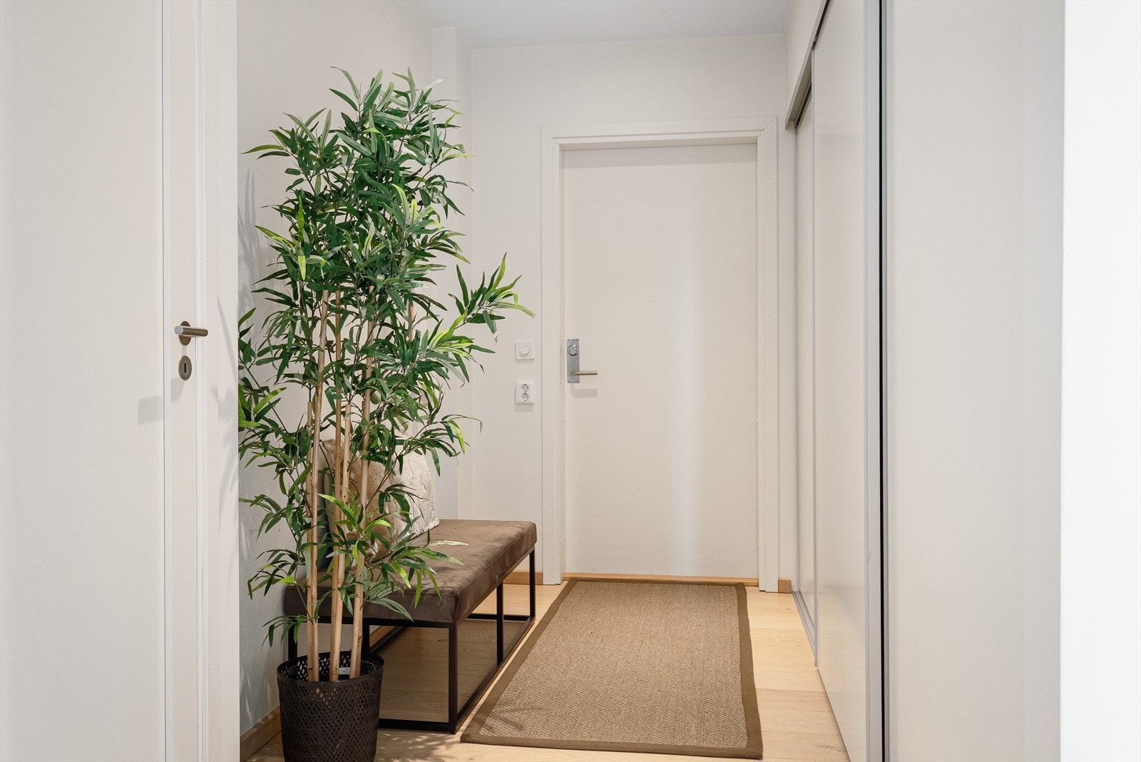 Entréen har plassbygget skyvedørsgarderobe og plass for entrémøbel Galleribilde