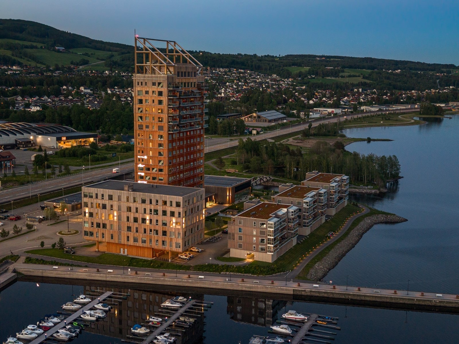 Mjøstårnet har en sentral beliggenhet ved utløpet av elven Brumunda og den lokale båthavnen. Herfra er det kort avstand til Mjøsbyene Hamar, Gjøvik og Lillehammer, med gode togforbindelser fra Brumunddal stasjon. Galleribilde