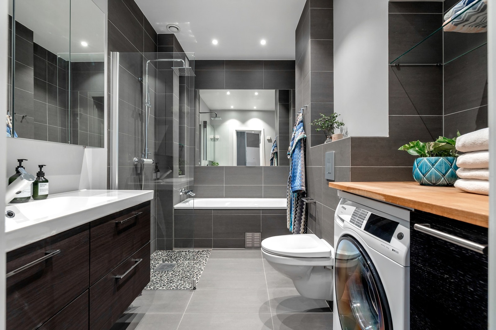Badet er flislagt og innredet med moderne løsninger, downlights i taket og varmekabler i gulvet. Galleribilde