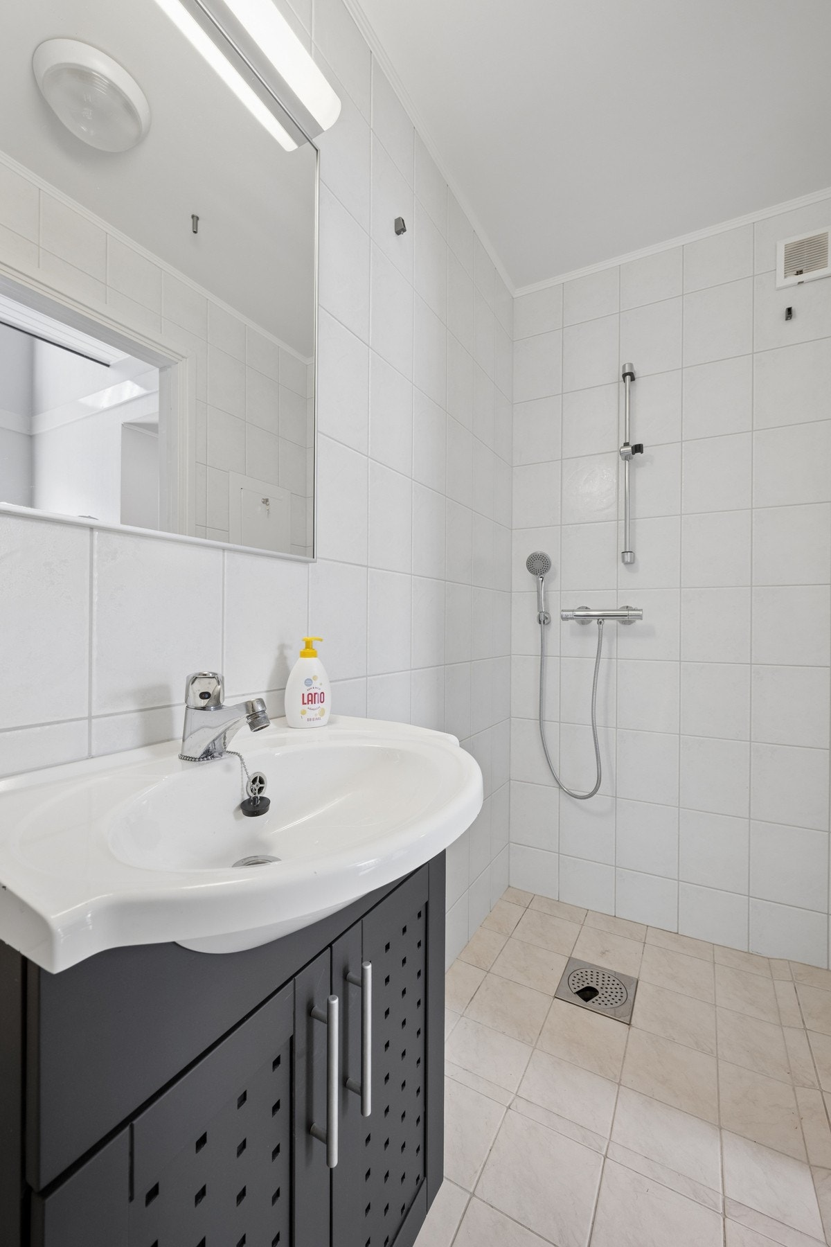 Badet i 1.etasje er flislagt med elektriske varmekabler i gulv. Innredning med servantseksjon, dusjsone og toalett. Galleribilde