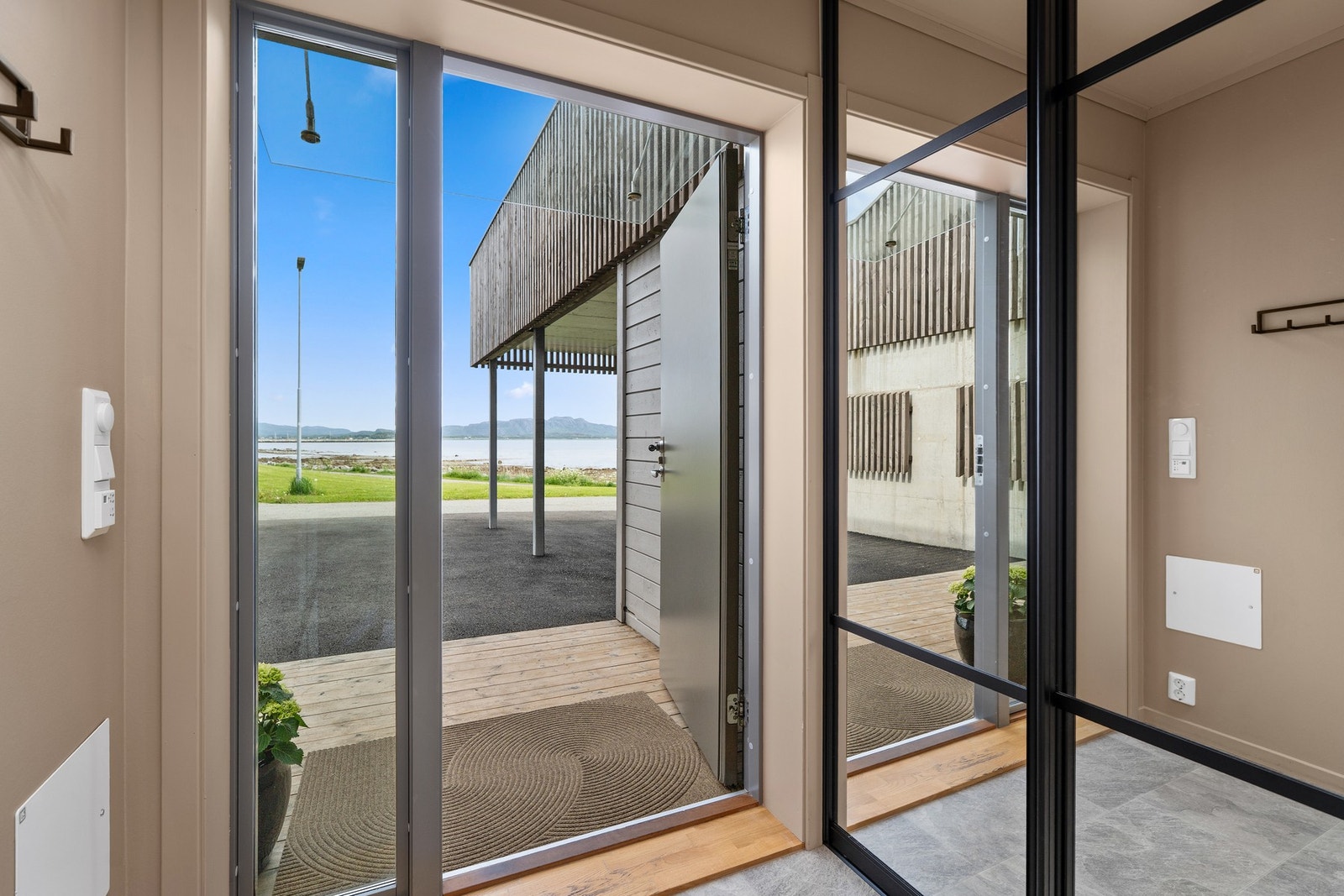 Entré. Moderne skyvedørsgarderobe i svart utførlese med glass. Galleribilde