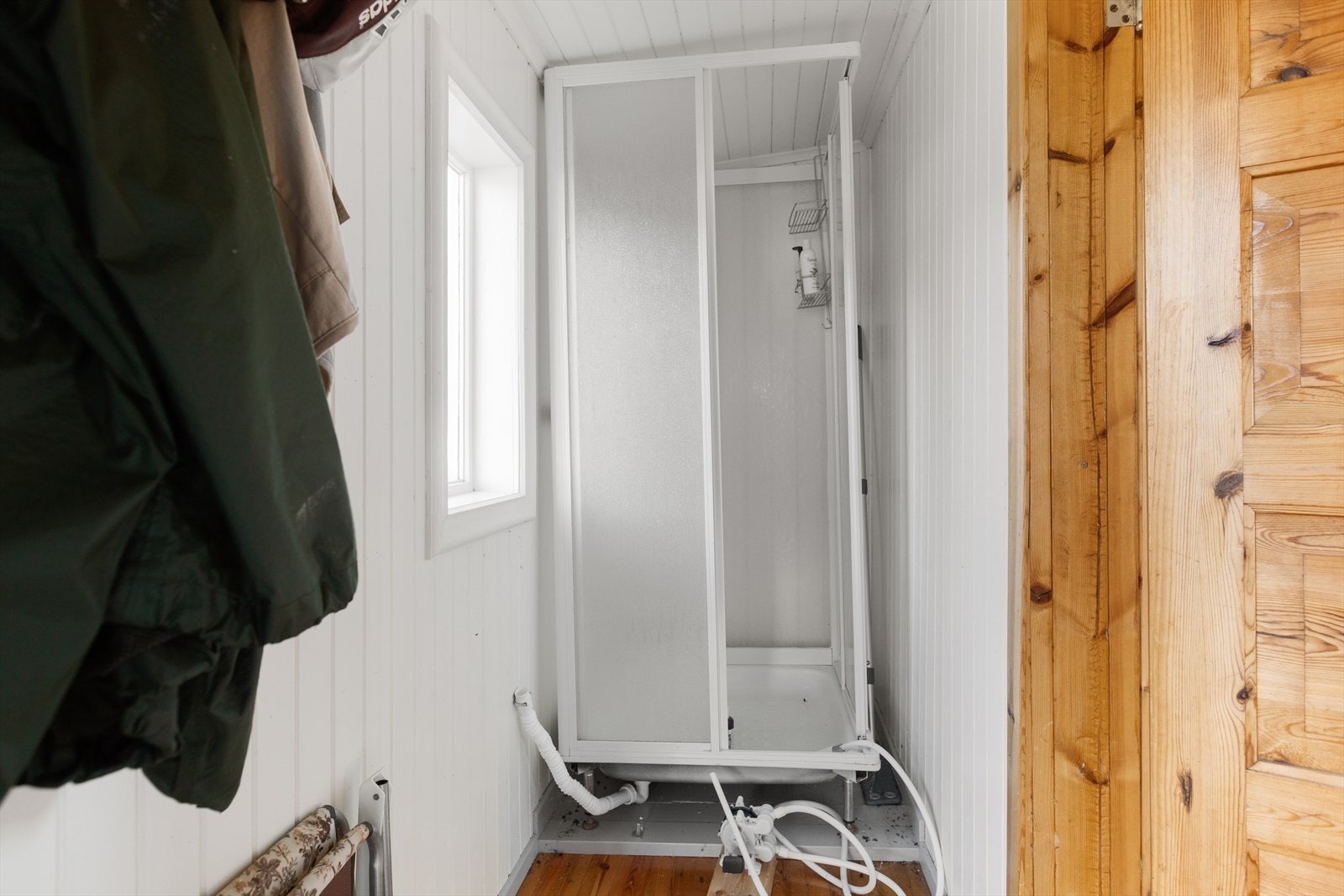 Gang med plass til yttertøy og sko. I gangen har eier installert et dusjkabinett med pumpe fra vannkanne - en praktisk løsning i ei hytte uten innlagt vann. Galleribilde