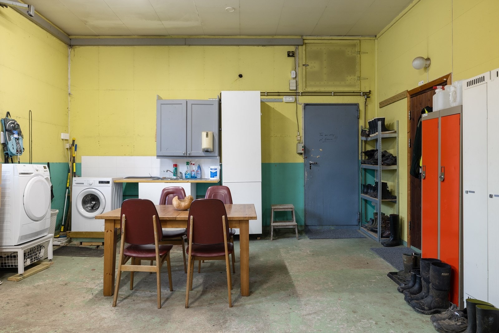 Praktisk innredet rom med vaskemaskin og pausekrok for gårdsdriften. Galleribilde