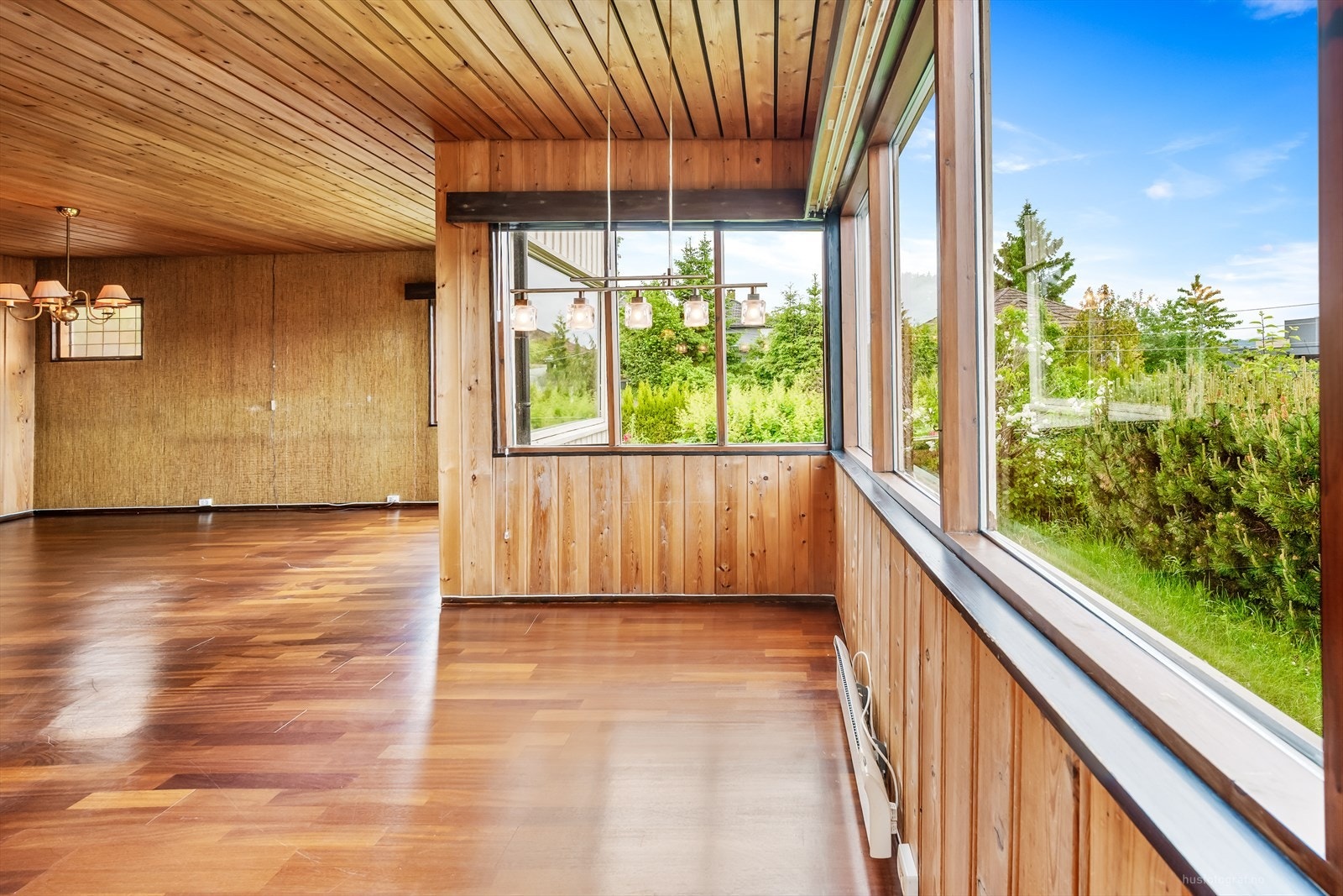 Den innglassede delen av stuen gir rikelig med lys og utsikt mot hagen. Galleribilde