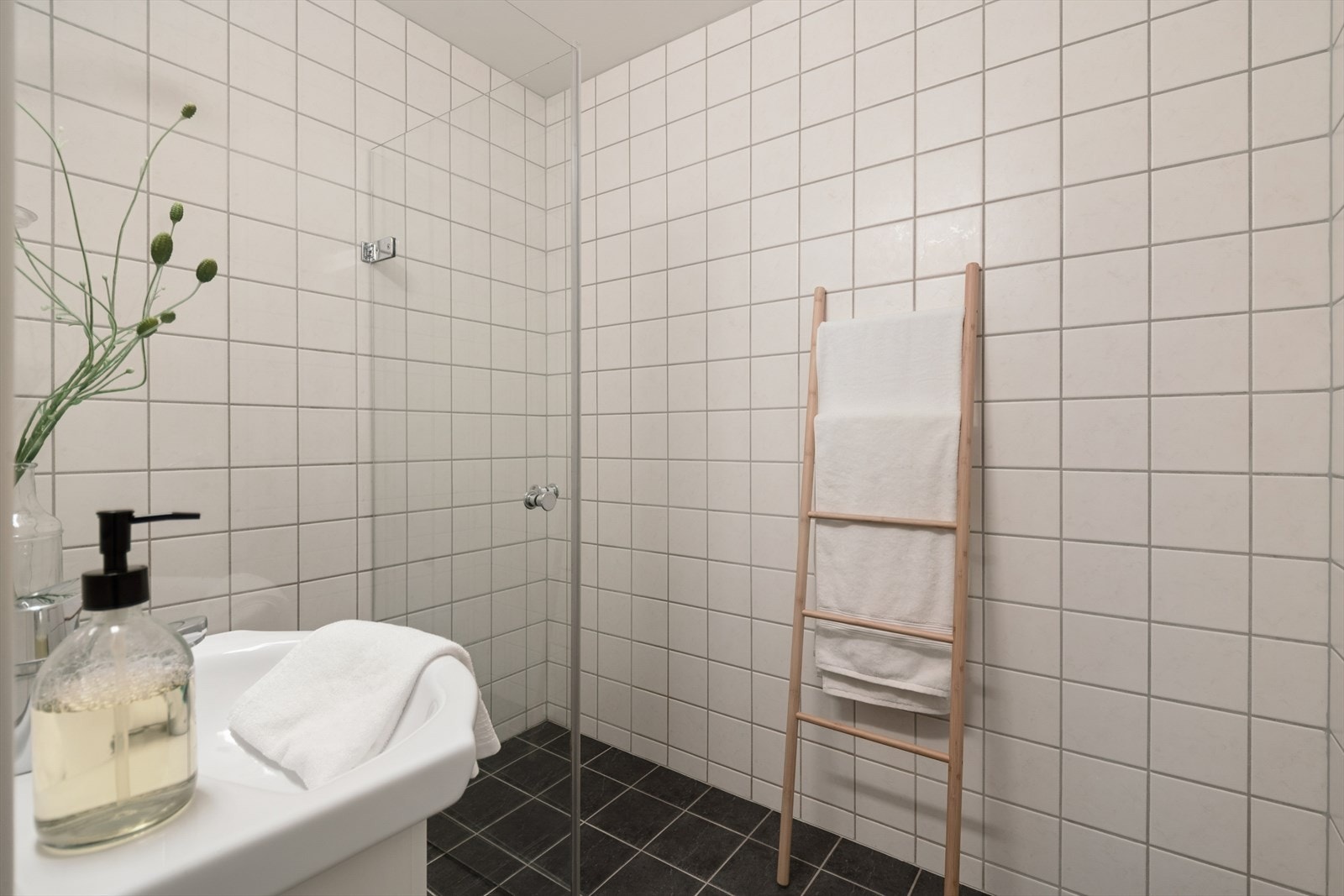 Badet har flislagt gulv med elektriske varmekabler og dusjhjørne med innfellbare vegger. Galleribilde