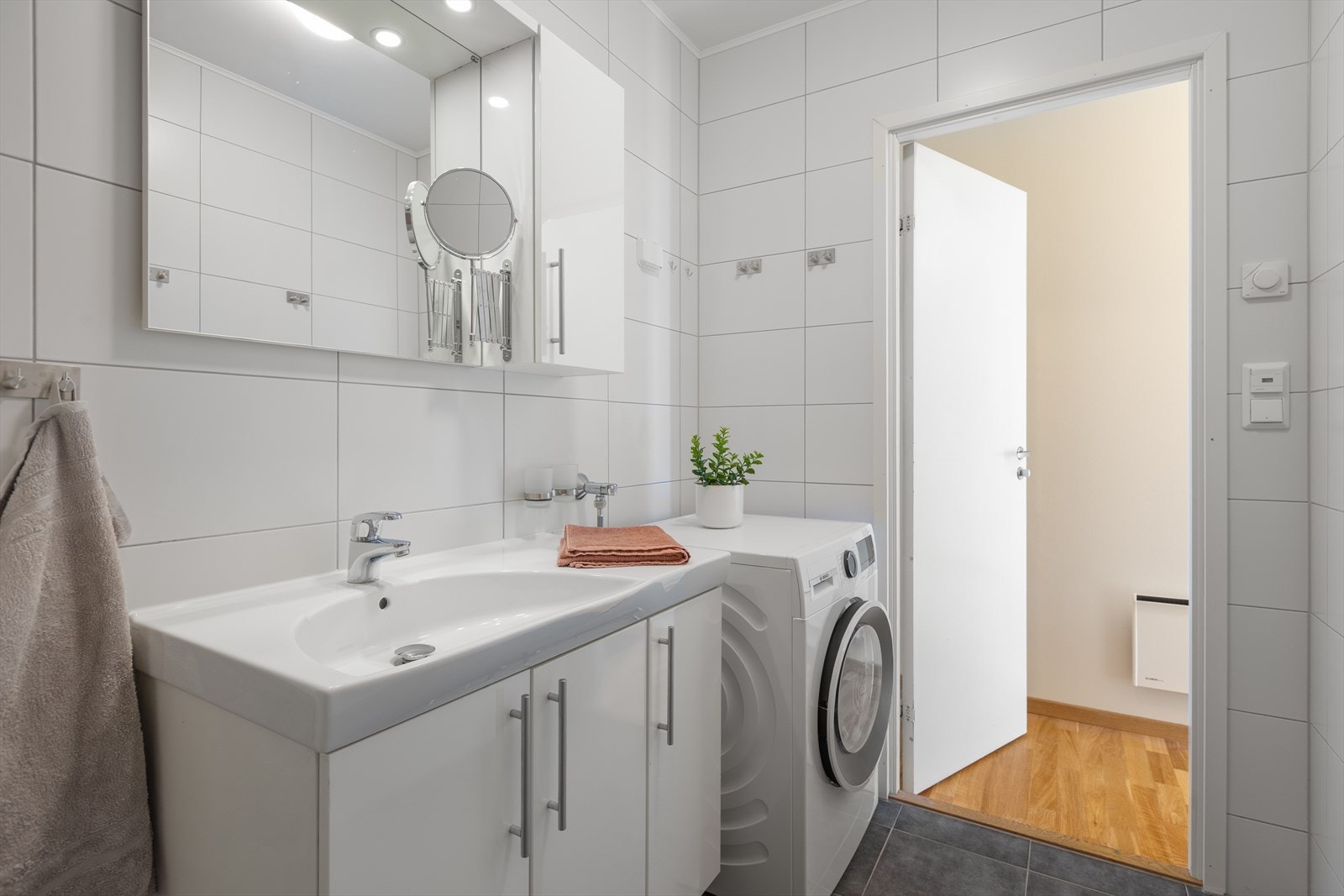 Badet har elektriske varmekabler i gulvet og praktisk opplegg for vaskemaskin Galleribilde