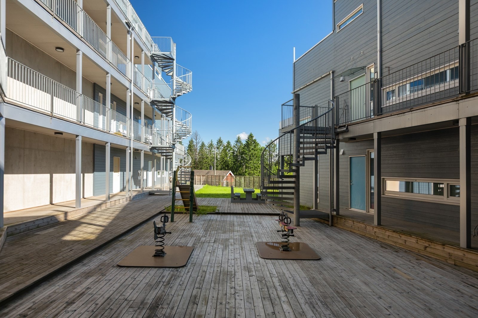 Fellesområdet er pent opparbeidet med plen, terrasser, sittebenk og noen lekeapparater for de minste Galleribilde