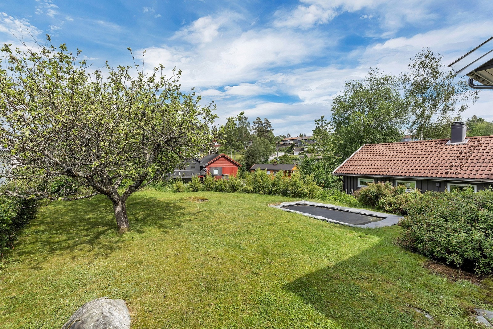 Hagen er pent opparbeidet med plen, beplantning og god plass til lek og uteopphold. Galleribilde