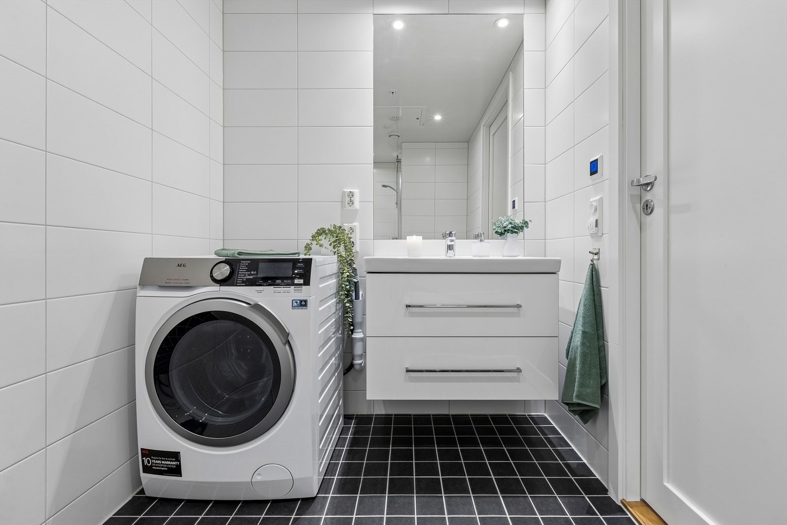 Flislagt bad med elektrisk gulvvarme og opplegg for vaskemaskin. Galleribilde