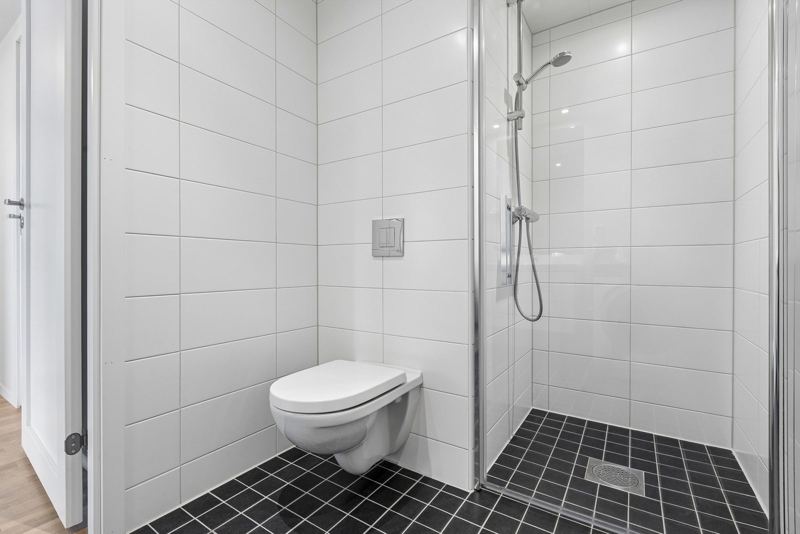 Badet er utstyrt med vegghengt toalett og dusjhjørne med innfellbare dører for å spare plass. Galleribilde