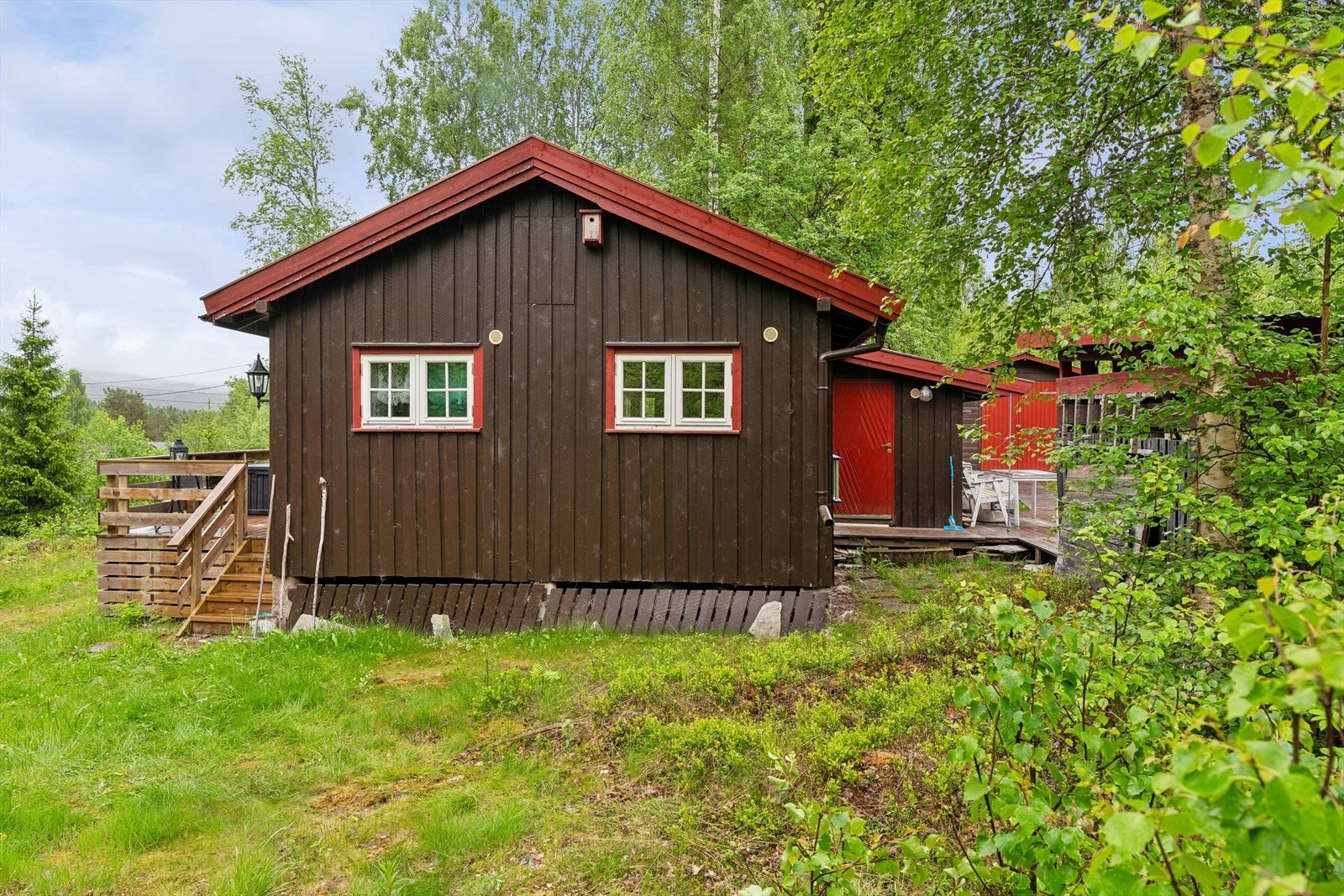 Baksiden av hytta med utgang fra kjøkkenet til en av uteplassene. Galleribilde