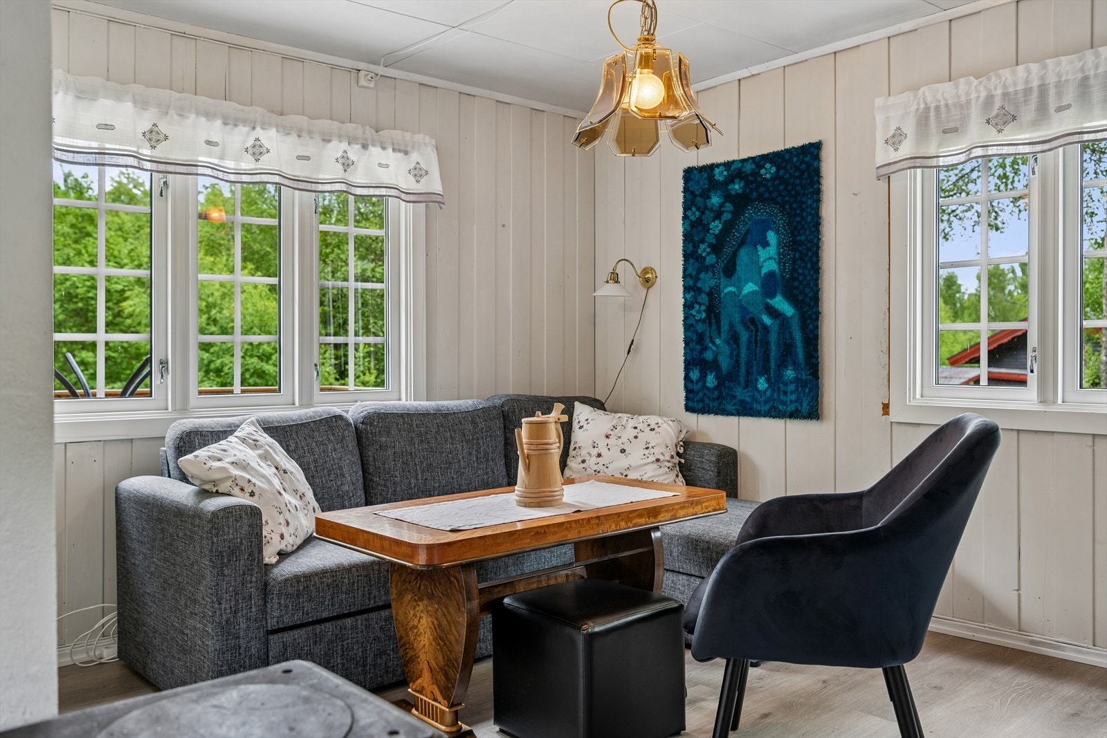 Vinduer med isolerglass fra 2021 slipper inn dagslys og rammer inn den grønne utsikten. Galleribilde
