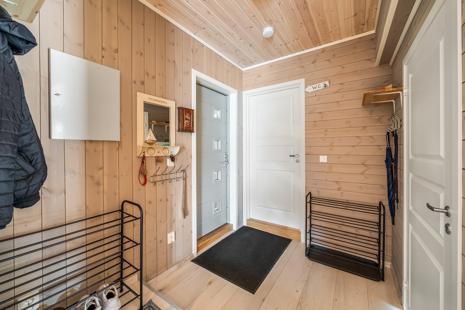 Gangen har plass til oppbevaring av yttertøy og sko. Vegger og himling har gjennomgående trepanel. Galleribilde