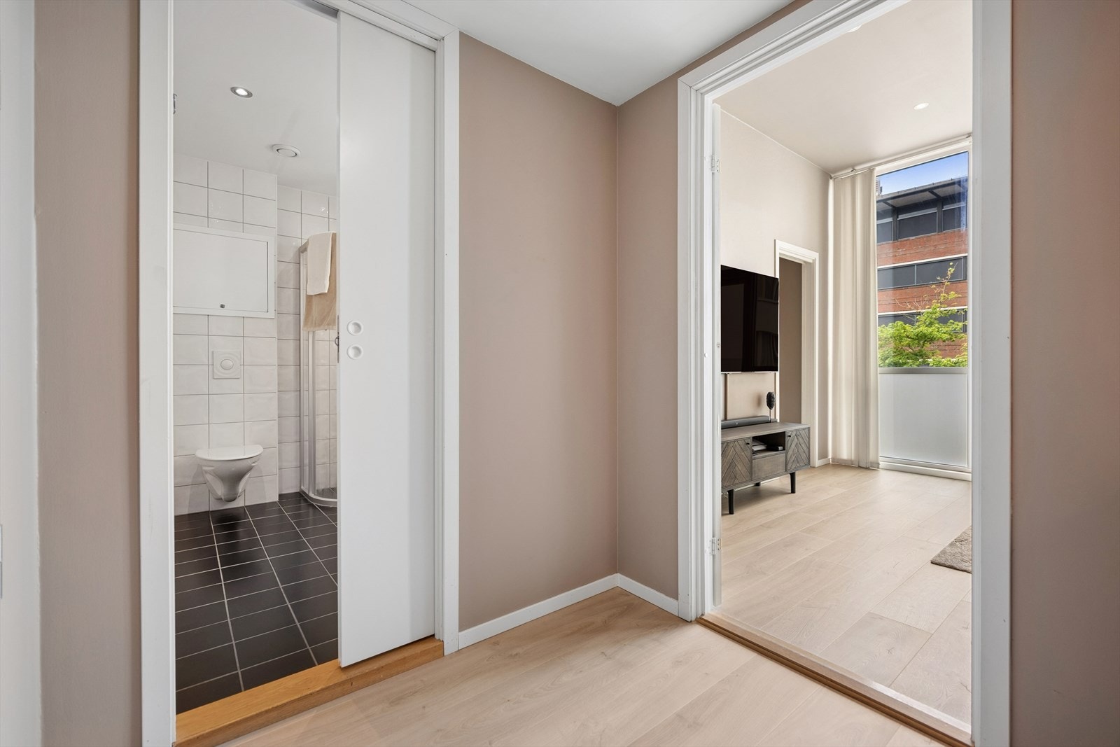 Badet er praktisk plassert ved entréen, med en plassbesparende skyvedør. Galleribilde