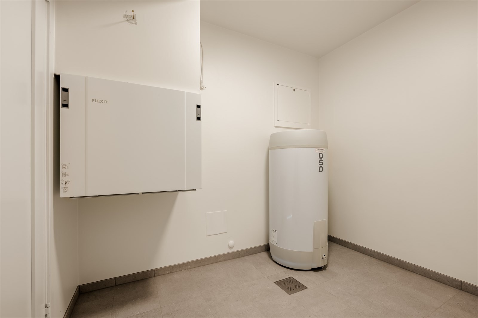 Praktisk bod med flislagt gulv og gulvvarme. Her er tekniske installasjoner som OSO 200L bereder og Flexit ventilasjonsanlegg samlet, samt at det er egen dør direkte til bakkeplan utenfor. Galleribilde