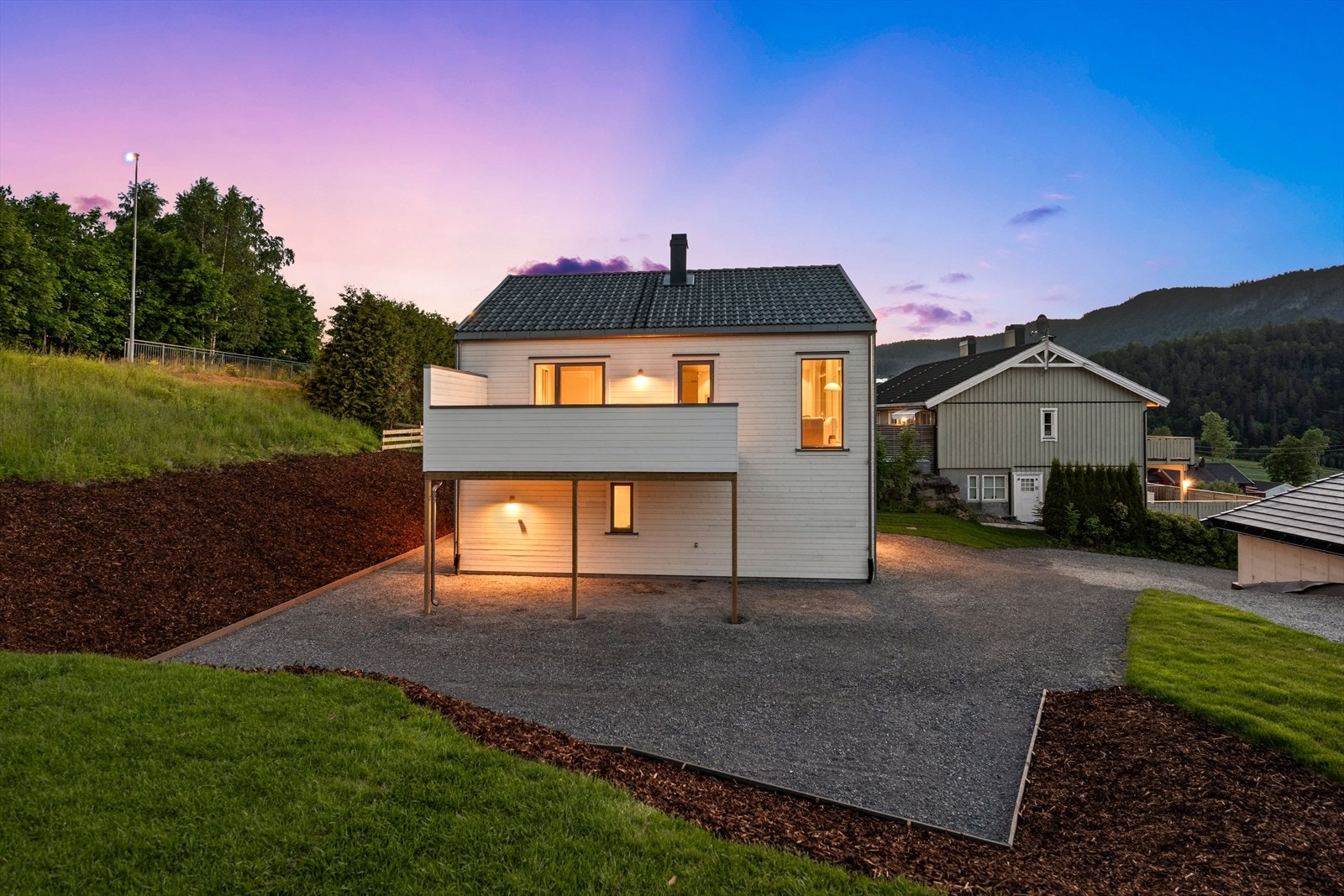 Praktisk carport integrert under terrassen. Carporten har selvdrenerende utekran og trekkerør for opplegg til elbillader. Galleribilde