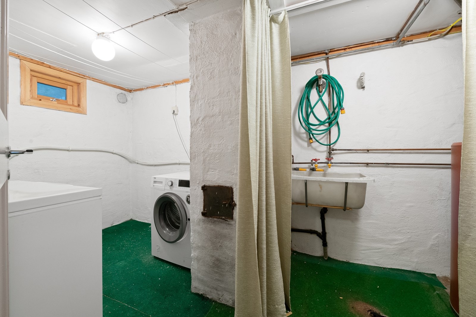 Vaskerommet i kjelleren har skyllekar og opplegg for vaskemaskin. Galleribilde