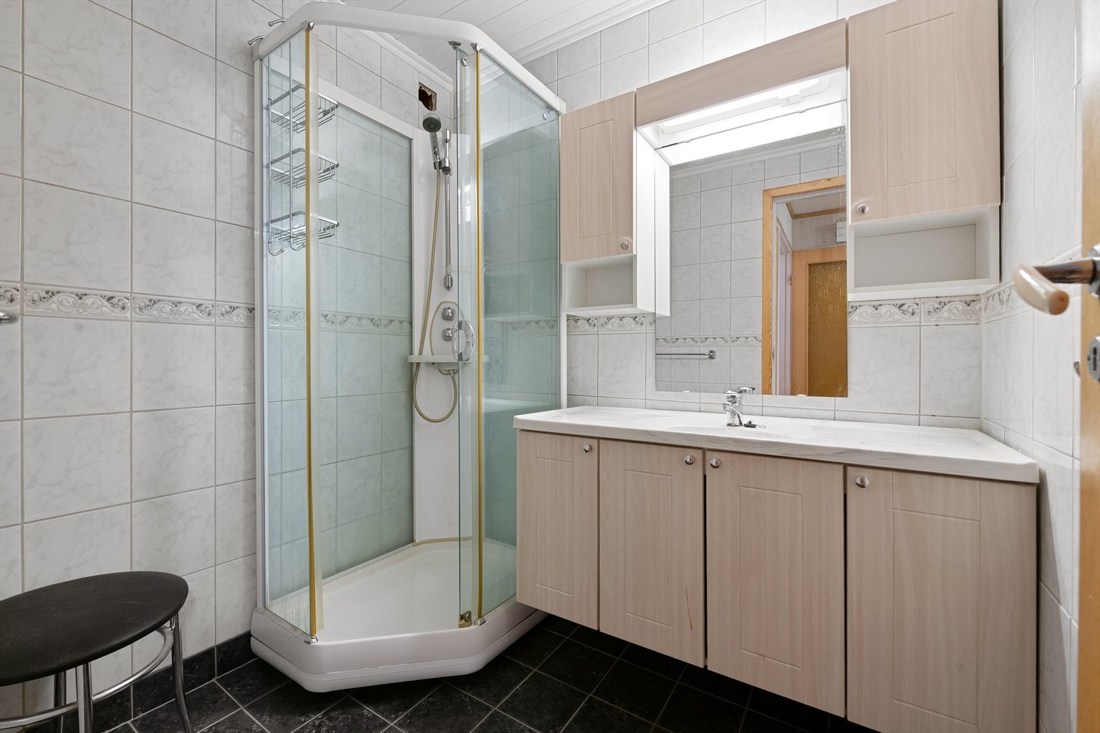 Badet har flislagt gulv med varmekabler og flislagte vegger, samt dusjkabinett og servantinnredning. Galleribilde