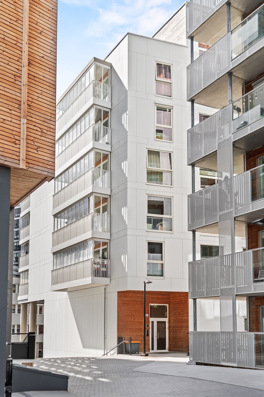 Fasadebilde av bygget som viser moderne arkitektur og pene fellesarealer. Leiligheten ligger i et attraktivt og urbant bomiljø. Galleribilde