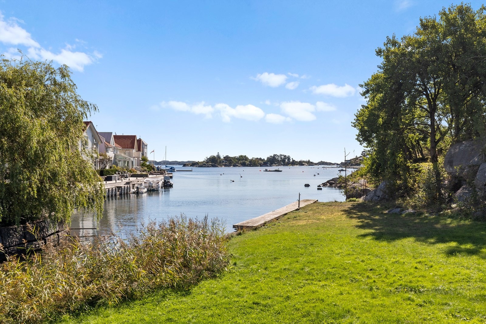 Langs fjorden venter svaberg, grønne plener og den innbydende sandstranden på Lofterødkilen - perfekt for bading, soling og rekreasjon på varme sommerdager. Galleribilde