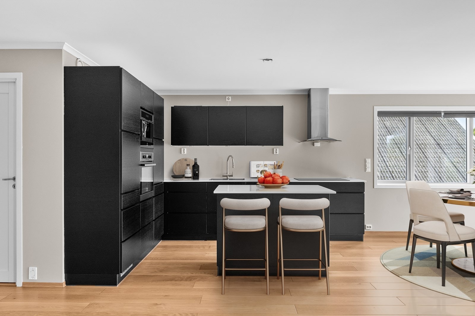 Kjøkkenet fremstår moderne og stilrent med innredning i tidløst design, glatte fronter og en eksklusiv benkeplate i kompositt. Den romslige kjøkkenøyen fungerer som et naturlig samlingspunkt i rommet, og byr på både ekstra arbeidsflate Galleribilde