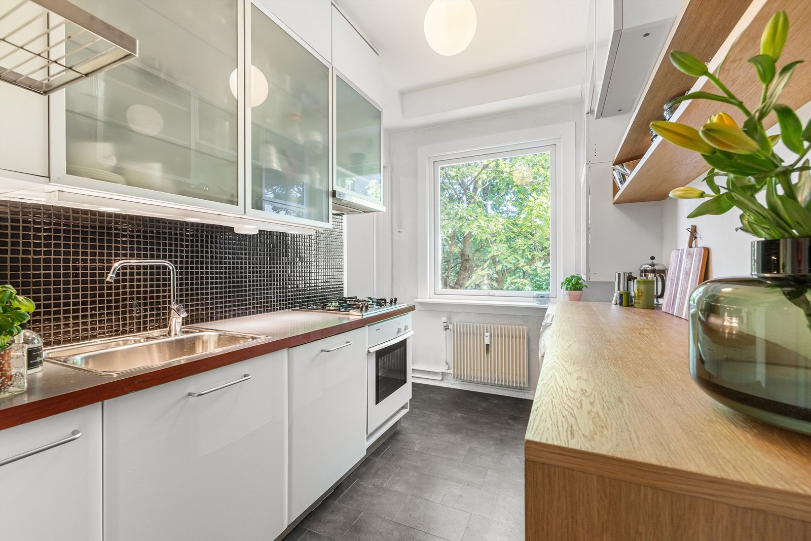 Kjøkkenet har en nyere foliert IKEA-innredning med platetopp på gass, stekeovn og oppvaskmaskin. Galleribilde
