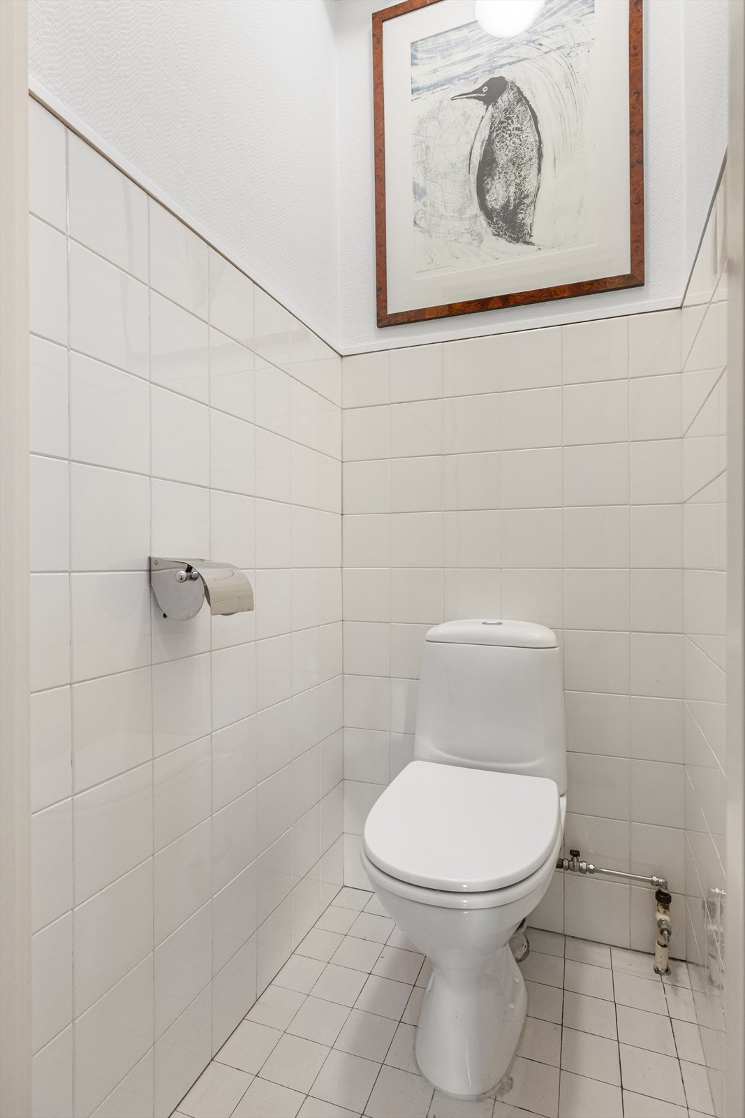 Separat toalettrom med gulvstående toalett og fliser på gulv og vegger. Galleribilde