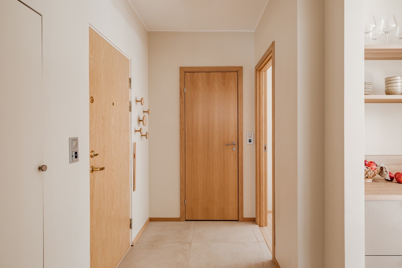 Entréen har flislagt gulv, lysmalte vegger og downlights i himlingen. Dører i eikefiner gir et påkostet og helhetlig uttrykk som harmonerer med resten av boligen. Galleribilde
