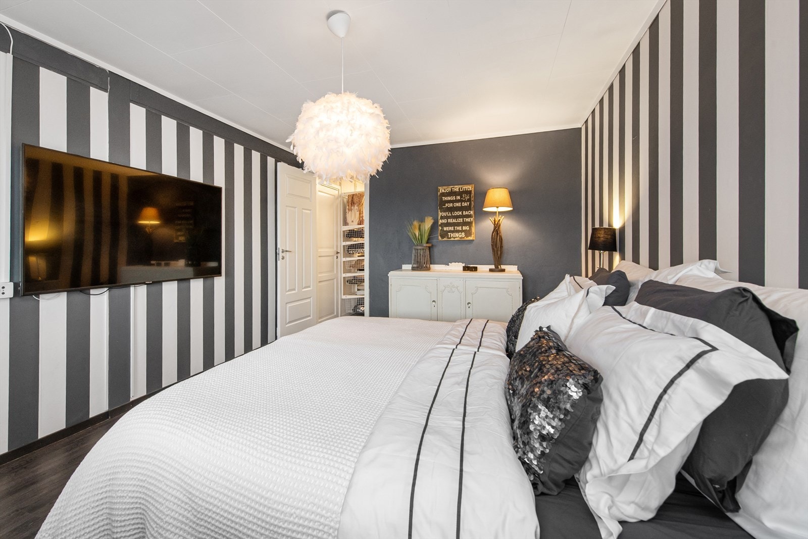 Hovedsoverom med stripet tapet og plass for stor TV. Galleribilde
