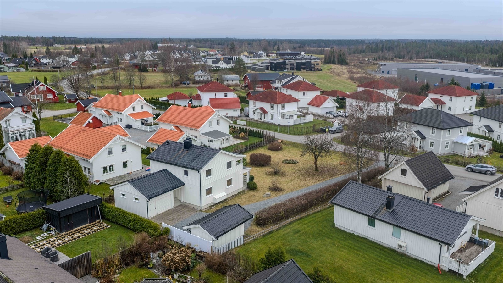 Eiendommen har to garasjer, elbillader og parkeringsmulighet i gårdsplassen. AI generert fra vinterbilder til uten snø Galleribilde