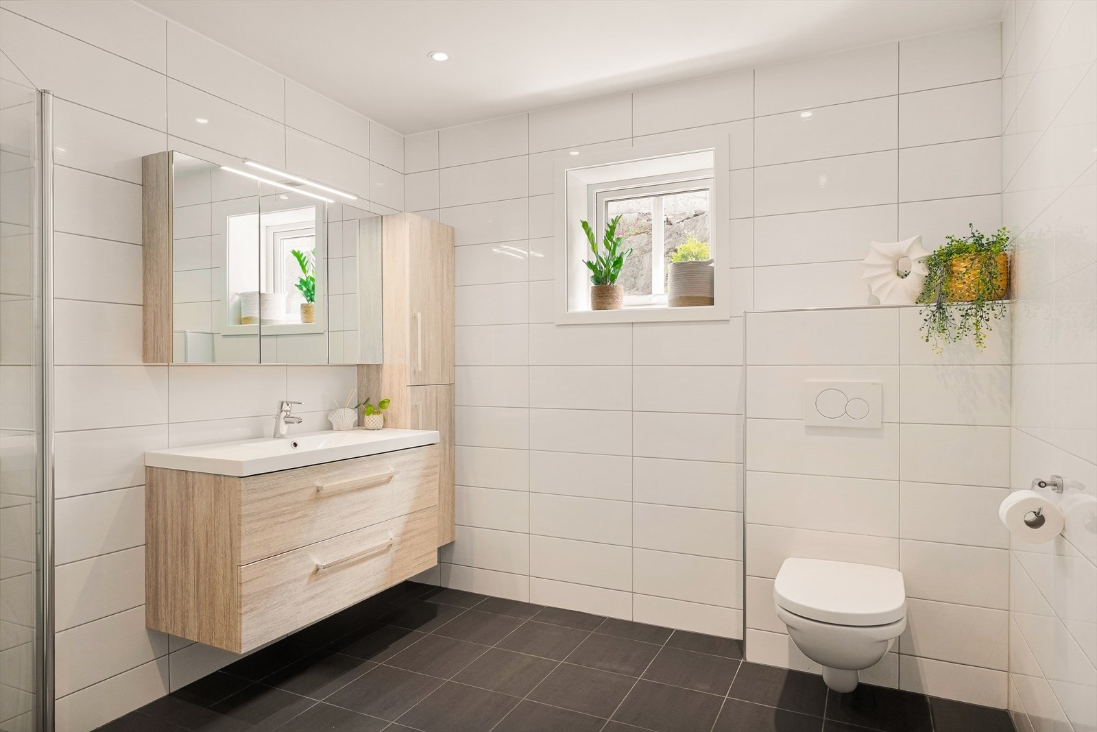 Badet i første etasje er flislagt og har vegghengt toalett og innredning med nedfelt servant. Galleribilde