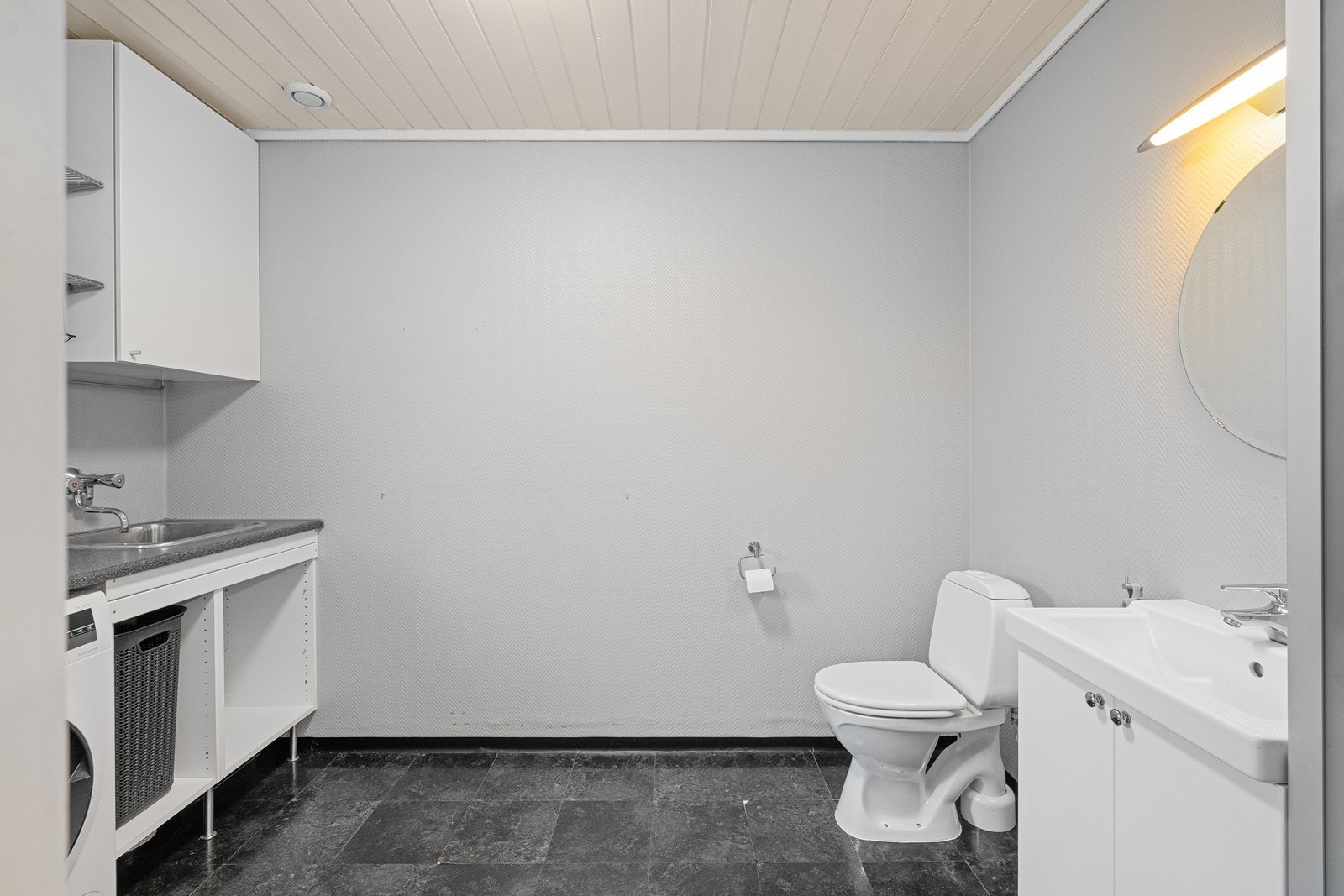 Rommet er innredet med en god arbeidsbenk og vask, som gir gode arbeidsflater og effektiv bruk i hverdagen. Vaskerommet har også toalett og vask, som bidrar til en praktisk og effektiv løsning i hverdagen. Galleribilde