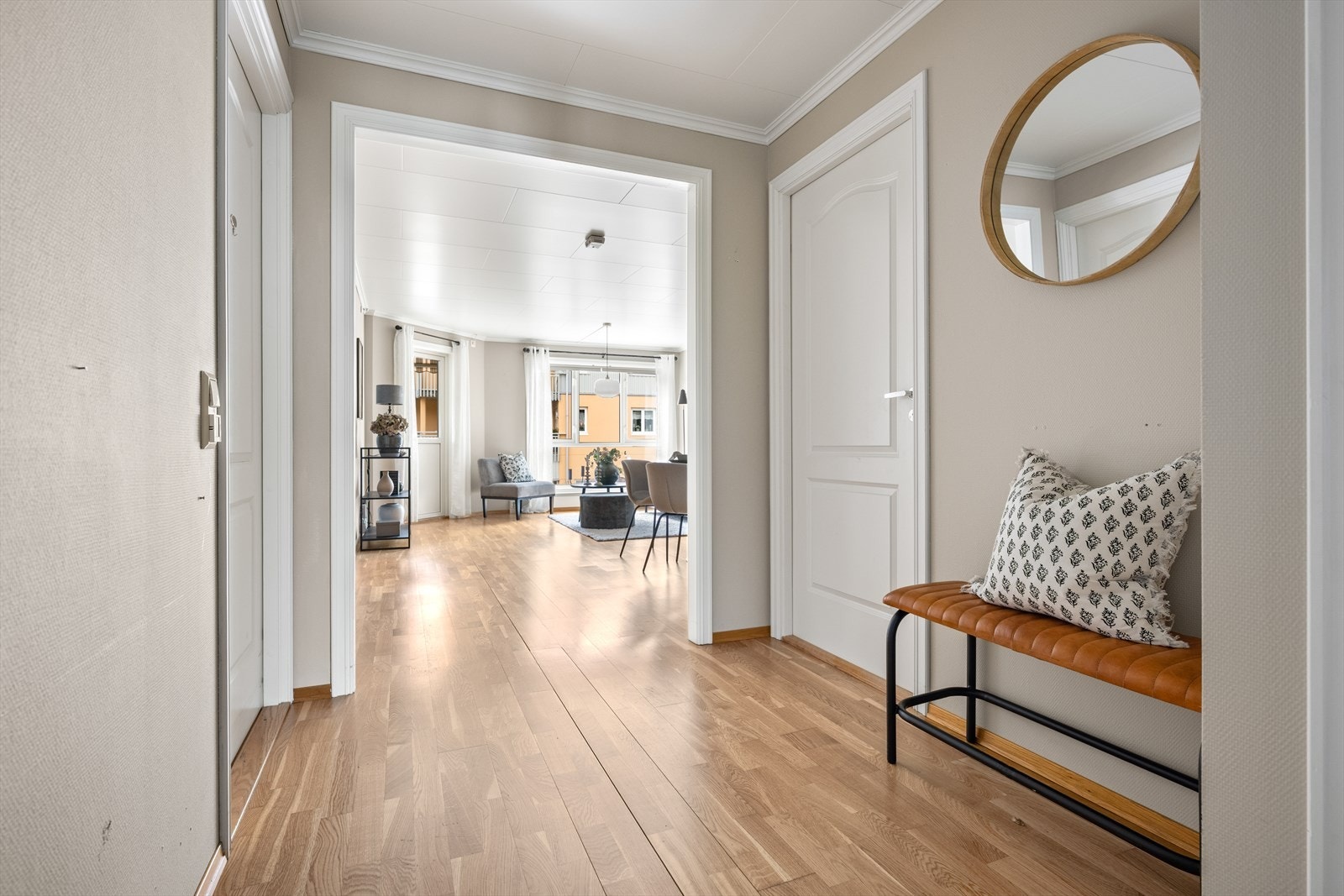 Fra gangen er det åpen siktlinje inn mot stuen. Gjennomgående parkettgulv i oppholdsrommene. Galleribilde