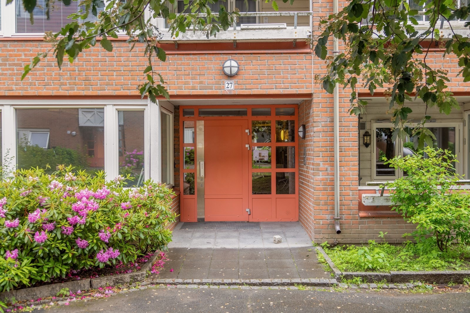 Inngangspartiet til blokka fra bakgården i grønne omgivelser. Galleribilde