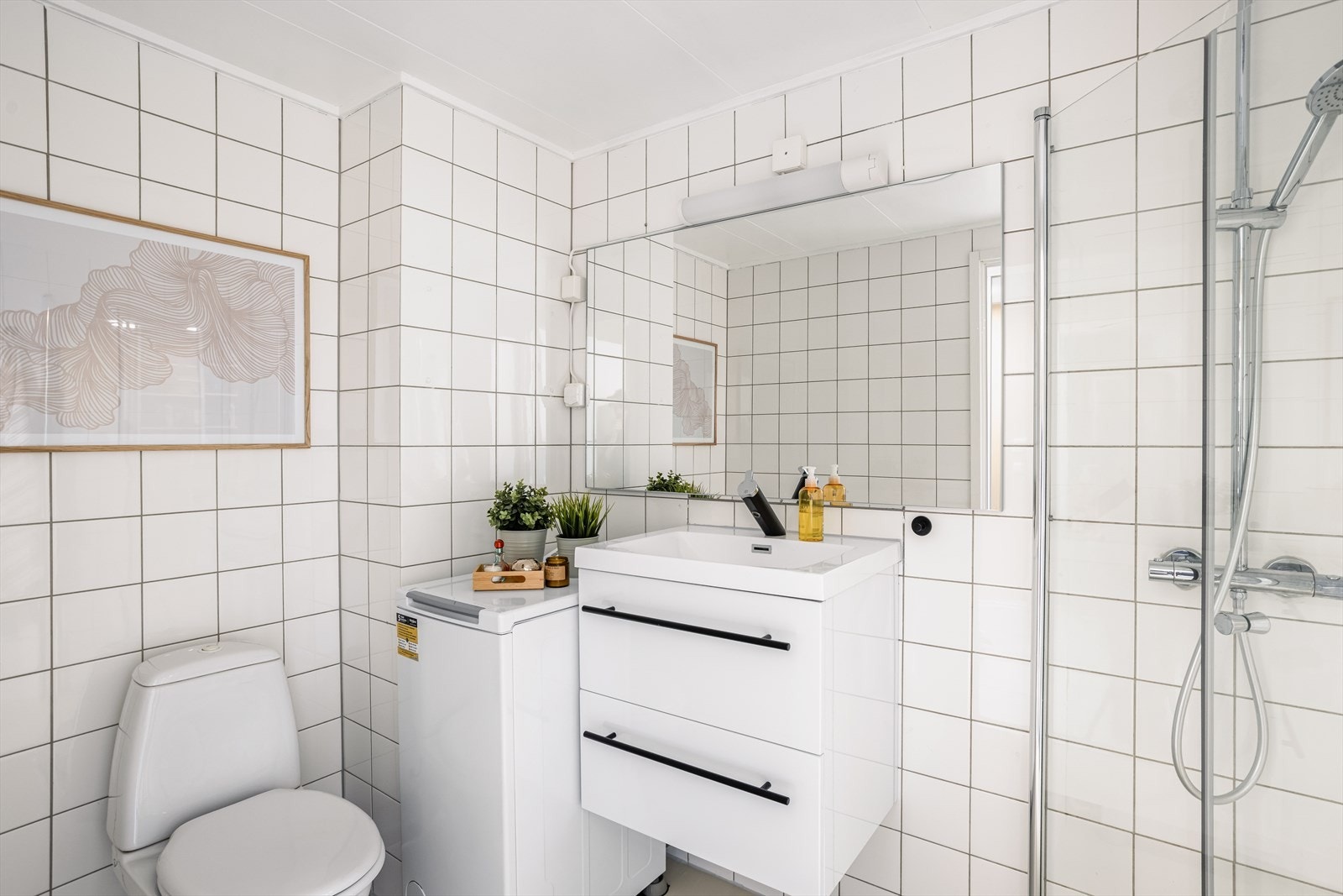 Tidløst og prefabrikert bad med mikrosement på gulv, fliser på vegger, standard innredning, gulvvarme, dusjhjørne og opplegg for vaskemaskin. Galleribilde