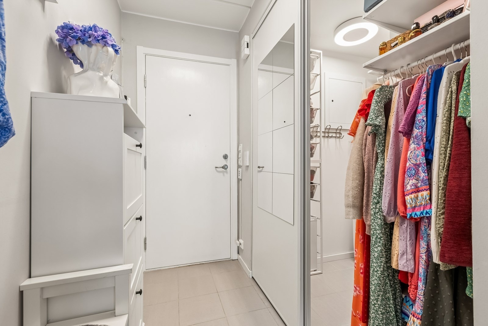 En skyvedør fra entréen åpner inn til en romslig garderobe for effektiv oppbevaring. Galleribilde