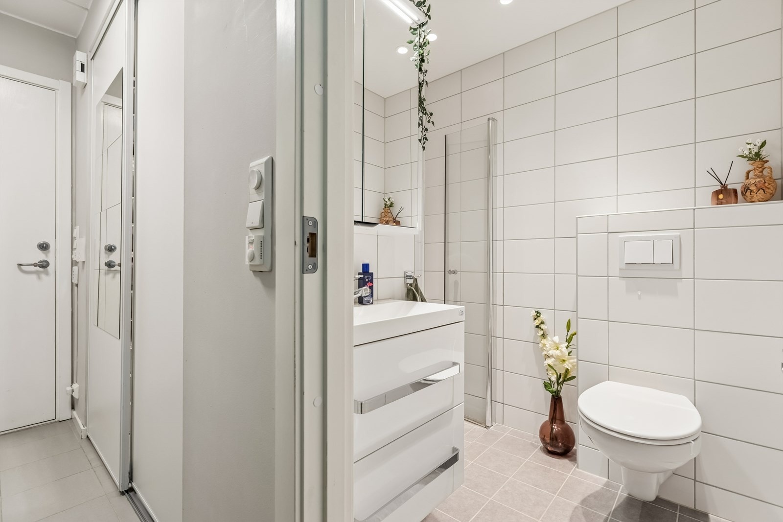 Rommet er utstyrt med vegghengt toalett, dusjhjørne med innfellbare dører og innfelte downlights i taket. Galleribilde