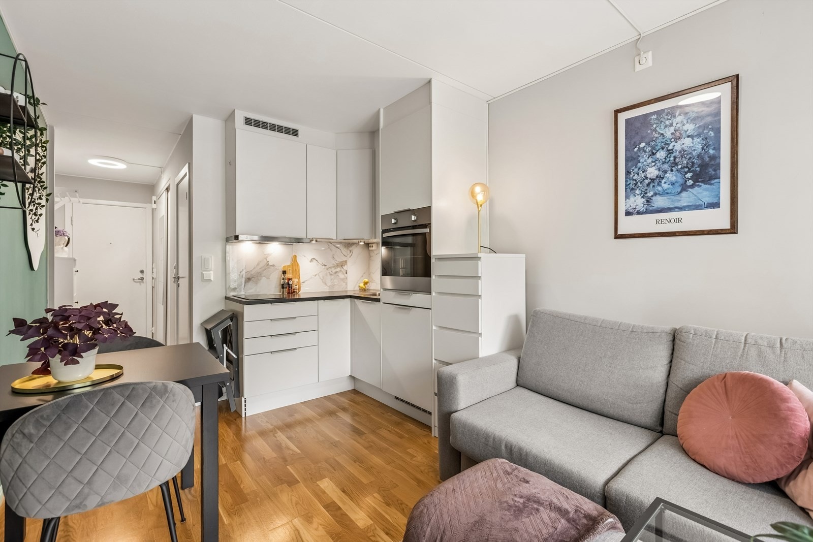 Leiligheten har en smart planløsning som utnytter plassen godt, med en kombinert sone for matlaging og avslapning. Galleribilde