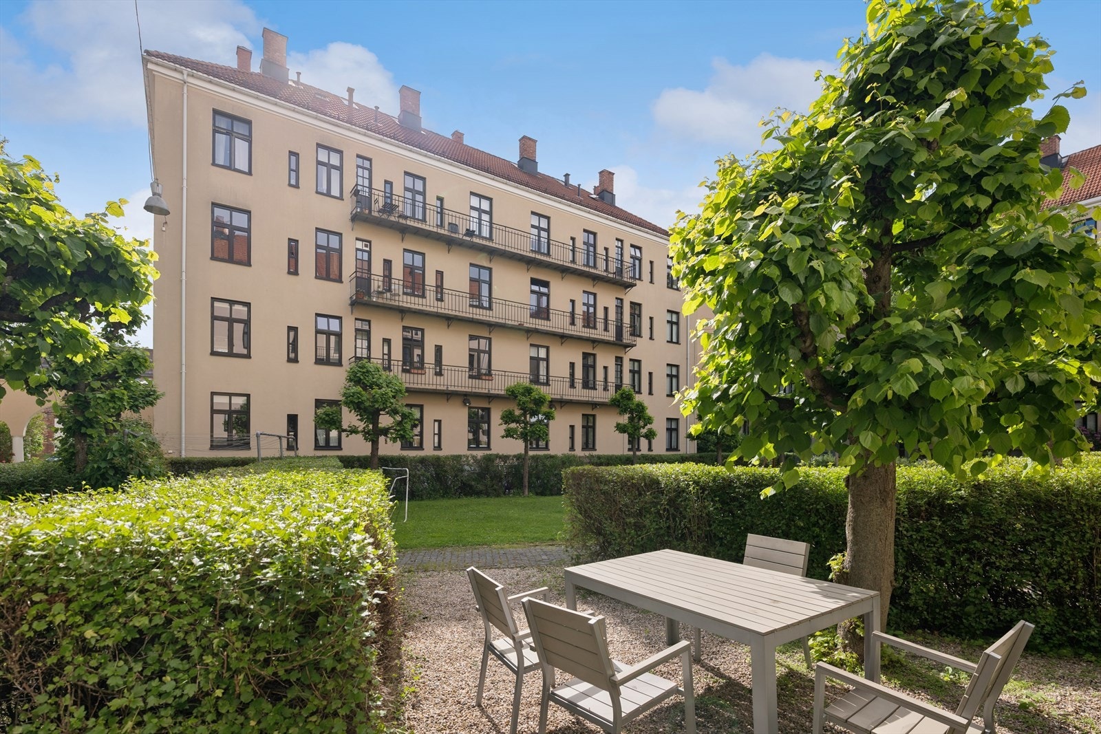 Den hyggelige bakgården er pent opparbeidet med variert beplantning og innbydende sittegrupper som skaper et grønt og trivelig uteområde. Galleribilde