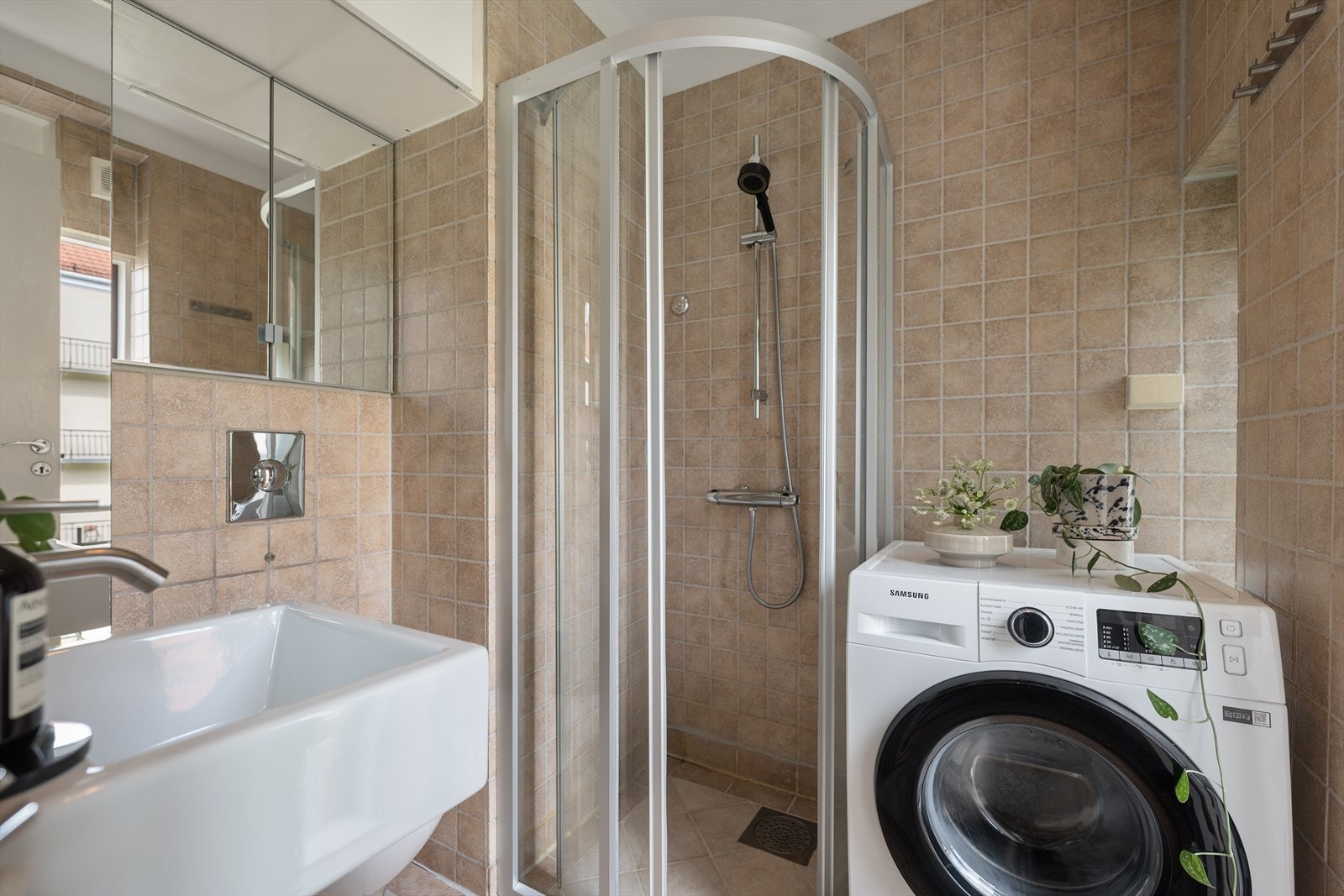 Badet fra 2005/2006 fremstår som praktisk og innbydende, med en effektiv planløsning. Her er det servant, veggmontert toalett og dusjhjørne med glassvegger, opplegg for vaskemaskin, samt skap for oppbevaring. Galleribilde